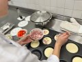 Rechteckige Form mit runden Mulden, darüber Hände